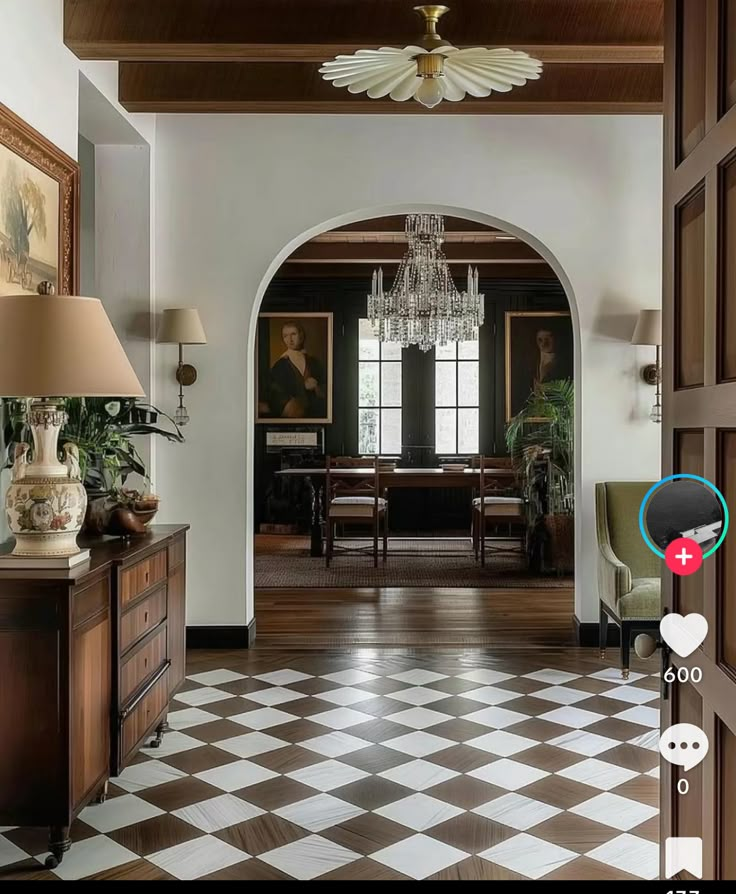 an open door leading to a living room with a chandelier hanging from the ceiling