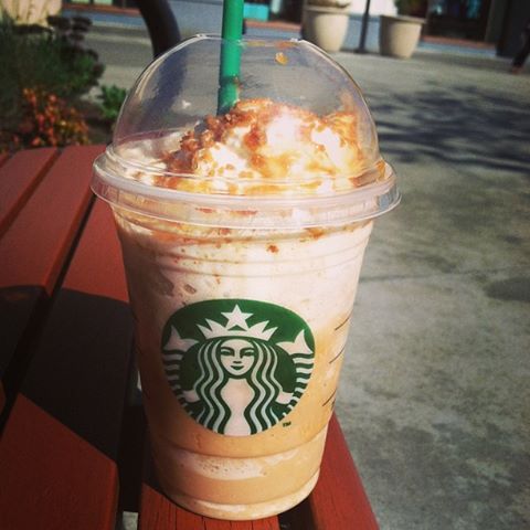 a starbucks drink sitting on top of a wooden table