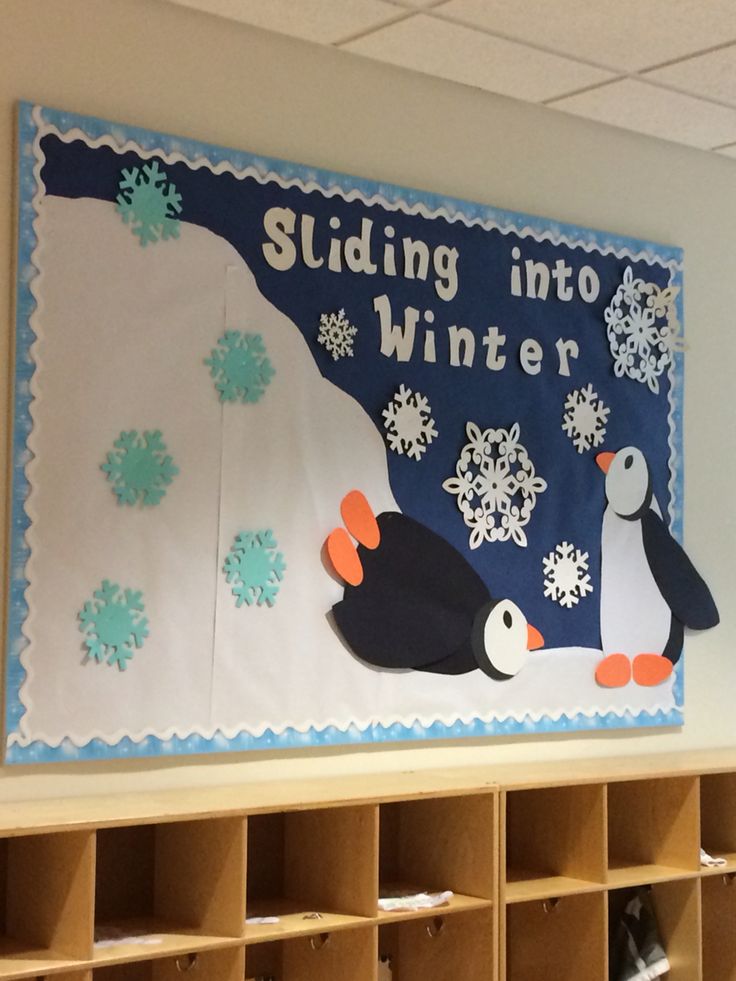 a bulletin board with penguins and snowflakes on it in a classroom setting that reads sledding into winter