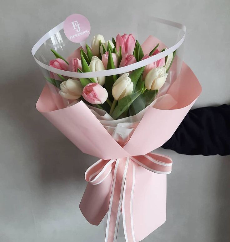 a bouquet of tulips wrapped in pink ribbon