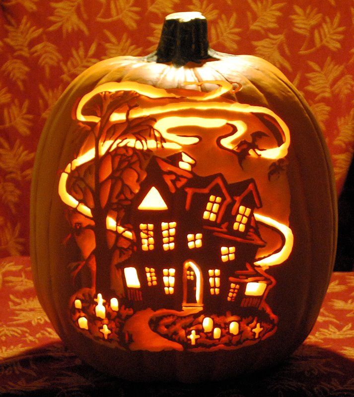 a carved pumpkin with an image of a house in the middle and candles lit inside