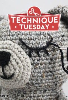 a crocheted teddy bear with a tag on it's ear and nose