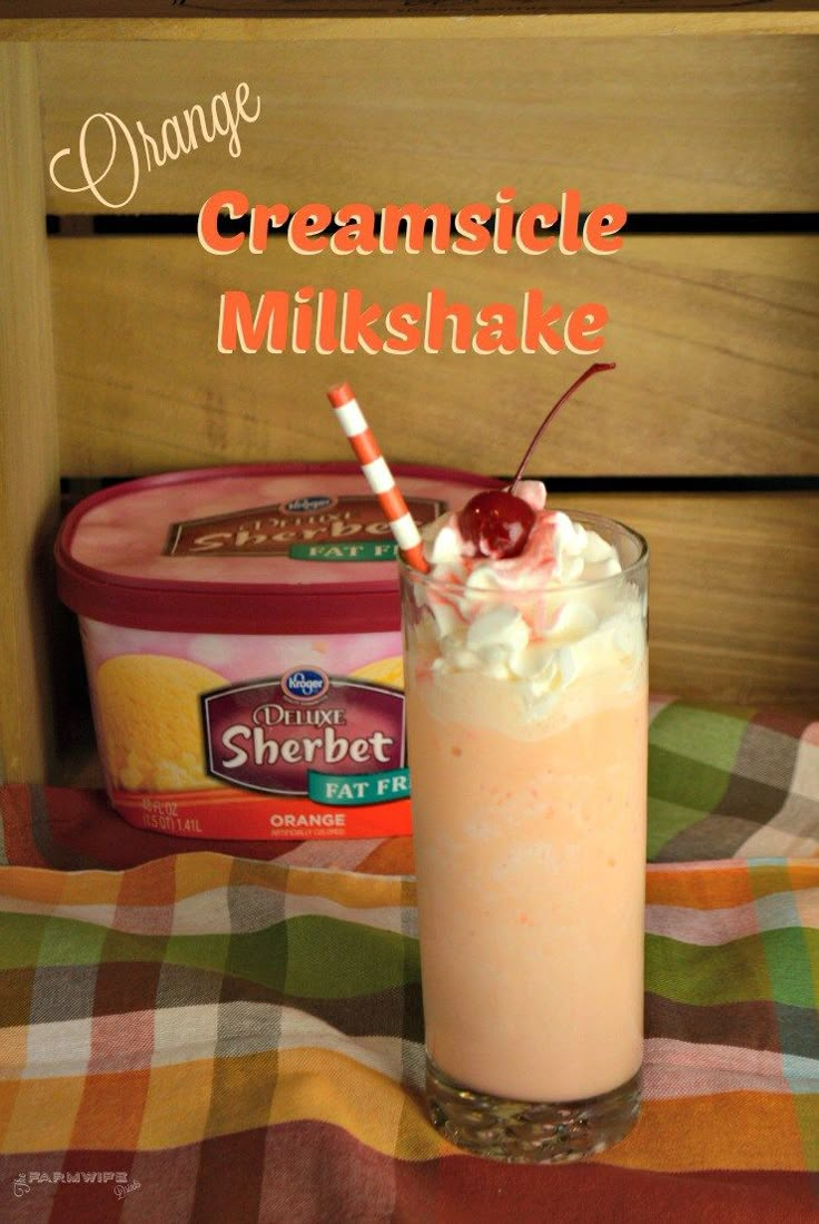 an orange creamsice milkshake with whipped cream and cherries