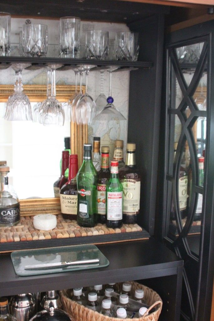 an open cabinet filled with liquor bottles and glasses