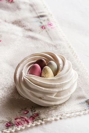 three small eggs in a white bowl on a tablecloth with pink and blue flowers