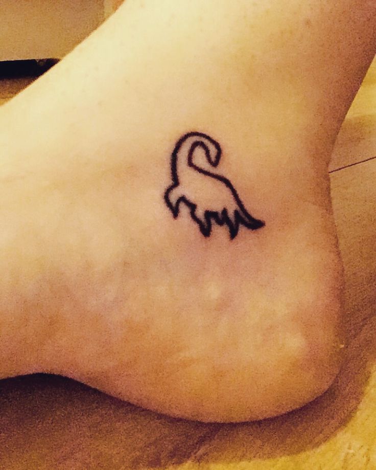 a foot with a tattoo on it that looks like a dog's head and tail