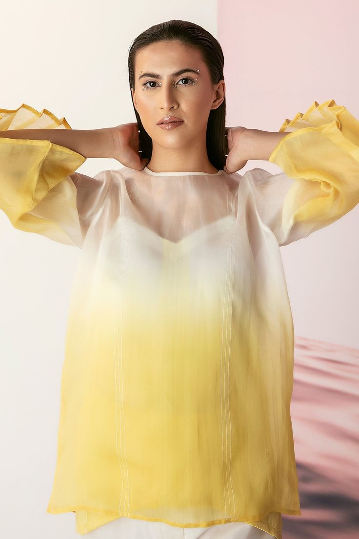 Yellow ombre top in organza base with Chrysanthemums hand done embroidery in yellow and white silk threads. Comes with ombre camisole.
Component: 2
Pattern: Embroidered
Type Of Work: Silk Thread Work
Neckline: Straight
Sleeve Type: Bell
Fabric: Organza
Color: Yellow
Other Details: 
Ombre pattern
Pleated sleeves
Note: The pant worn by the model is not for sale
Occasion: Party - Aza Fashions Yellow Top For Spring Wedding, Yellow Spring Wedding Top, Yellow Silk Top For Festive Season, Festive Yellow Silk Top, Yellow Summer Wedding Blouse, Yellow Silk Summer Tops, Ombre Pattern, Ombre Top, Yellow Ombre