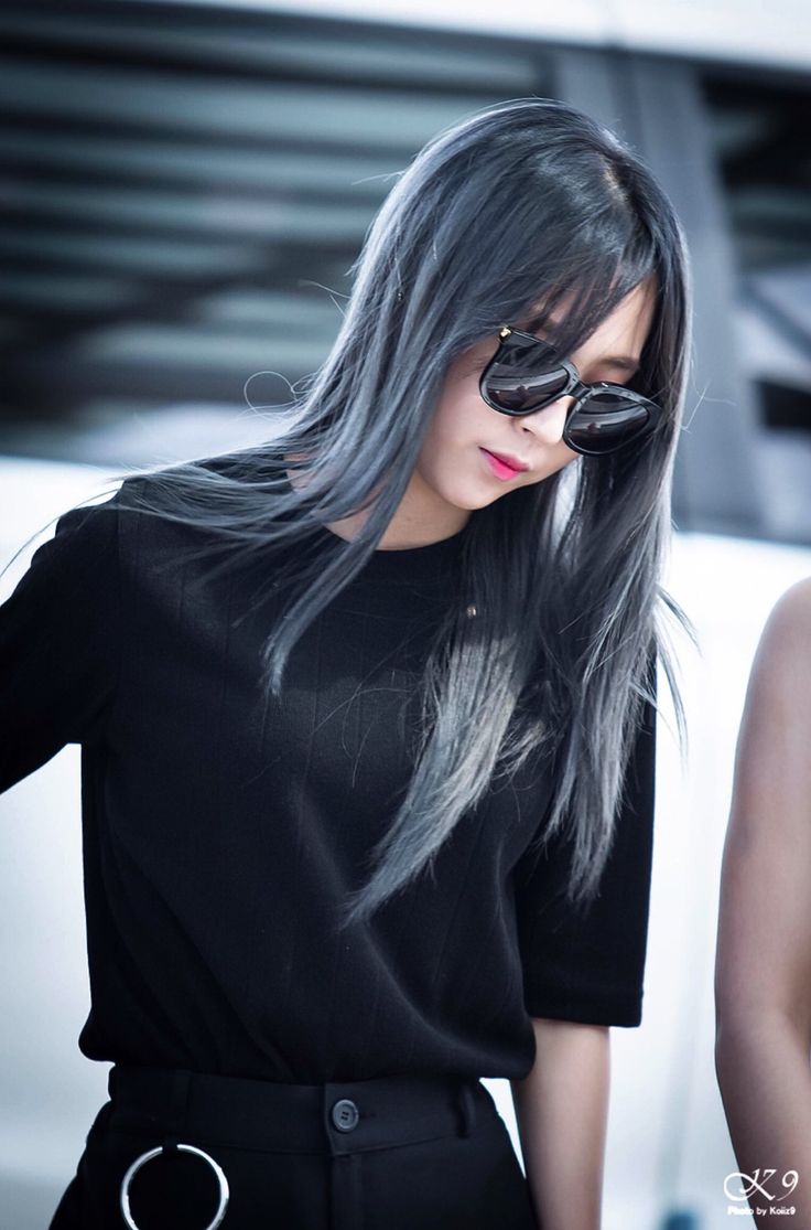 a woman with long grey hair and sunglasses