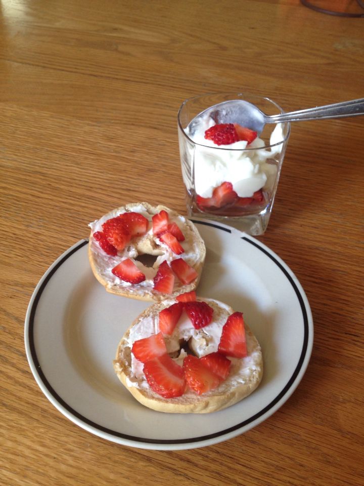 three small pastries on a plate with strawberries and whipped cream in the middle