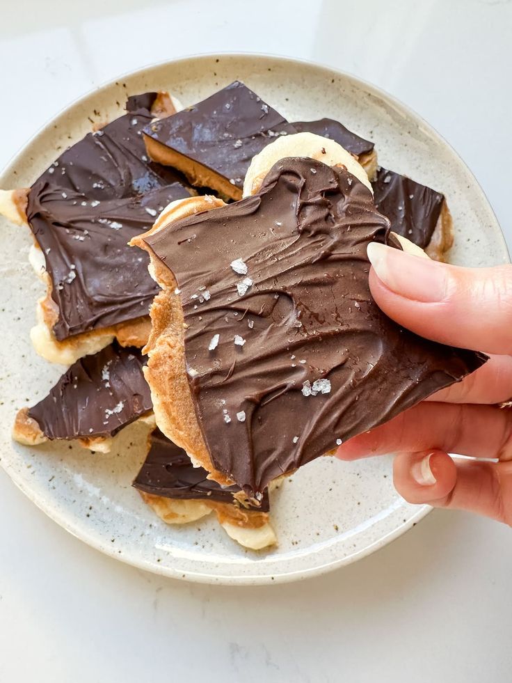 a person is holding a plate with some chocolate on it and peanut butter in the middle