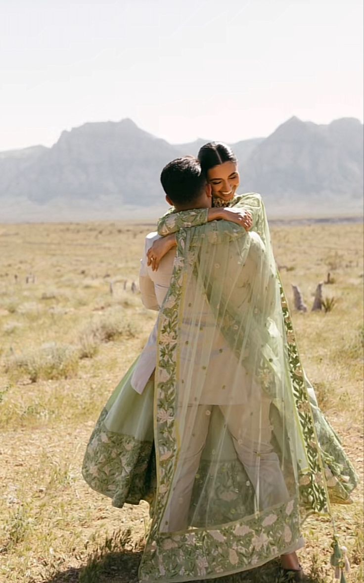 two women hugging each other in the desert