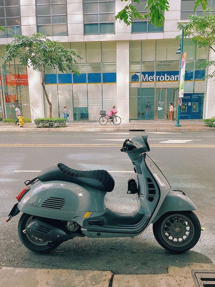 a scooter is parked on the sidewalk in front of a building