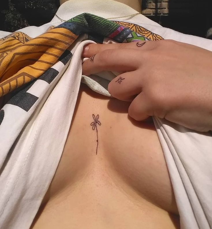 a woman with tattoos on her chest is laying in bed