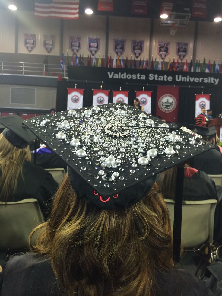 a graduate's cap is covered with white confetti in front of an audience