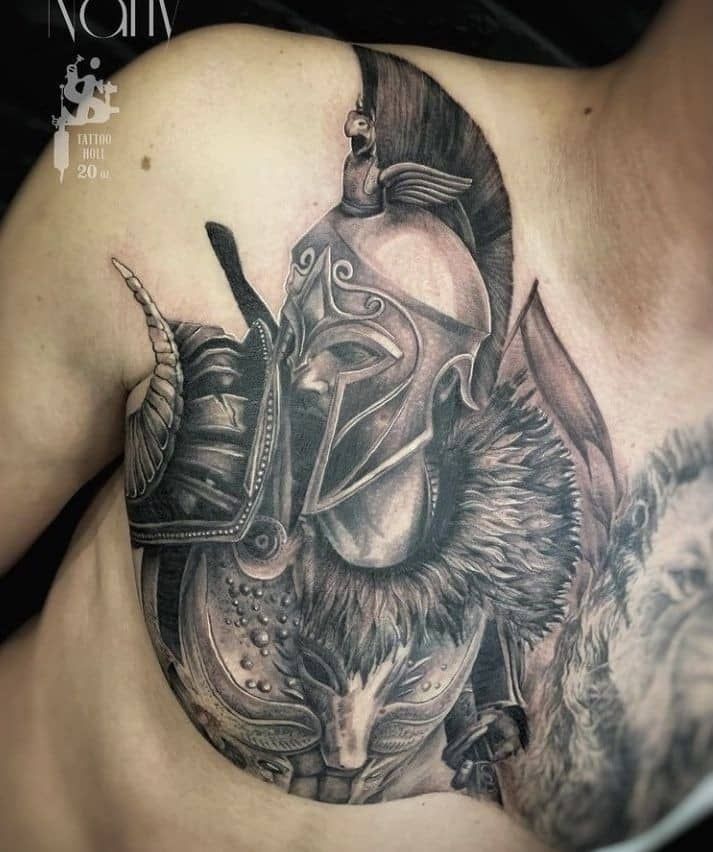 a man with a tattoo on his chest wearing a helmet and holding a knife in one hand