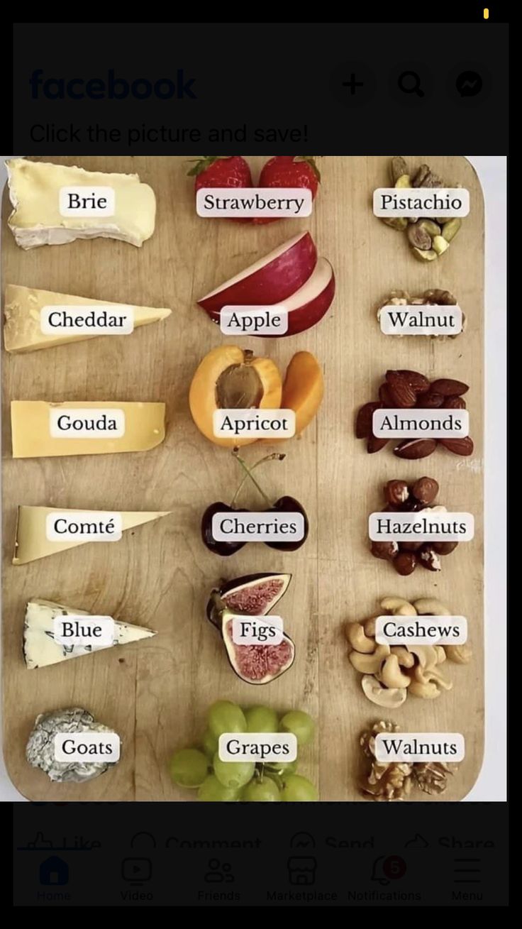 a wooden table topped with lots of different types of cheeses and fruits on top of it