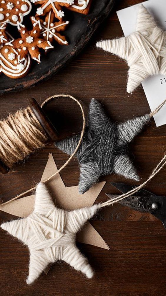 christmas decorations on a wooden table with scissors and twine spools next to them