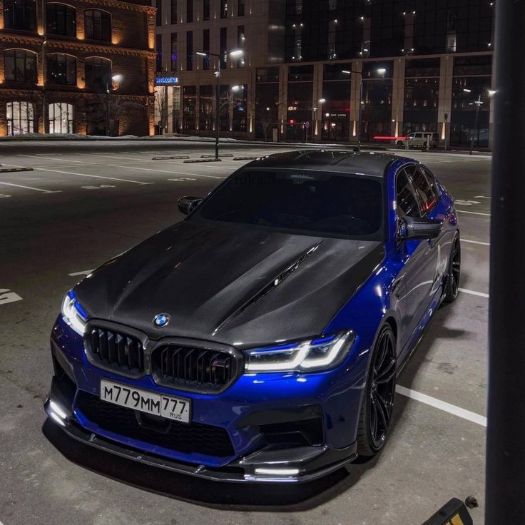 a blue car parked in the middle of a parking lot with no one around it