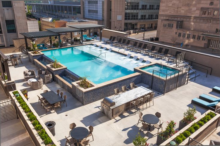 an aerial view of a rooftop pool with tables and chairs