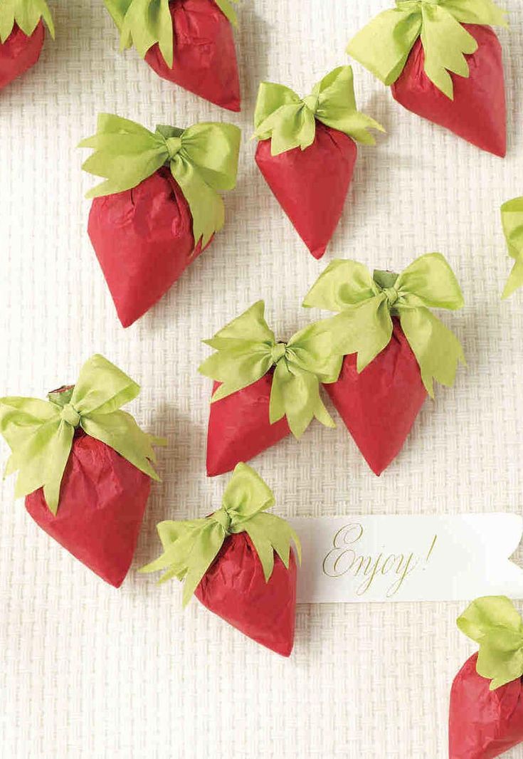 small red strawberries with green bows on them