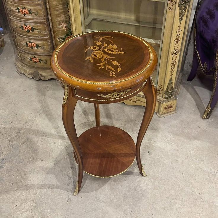 a small wooden table with an ornate design on it's top and bottom shelf