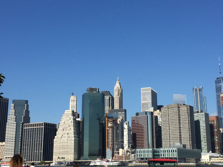 the city is full of tall buildings and boats in the water below it are palm trees