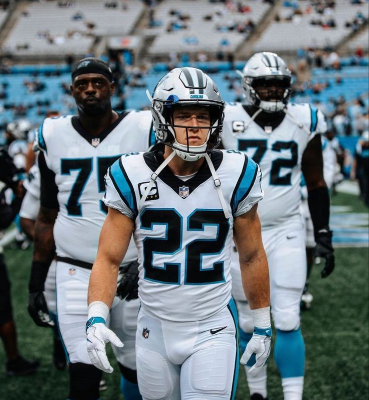 two football players are walking on the field