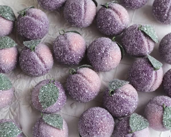 there are many purple candies with green leaves on them, and one is covered in glitter