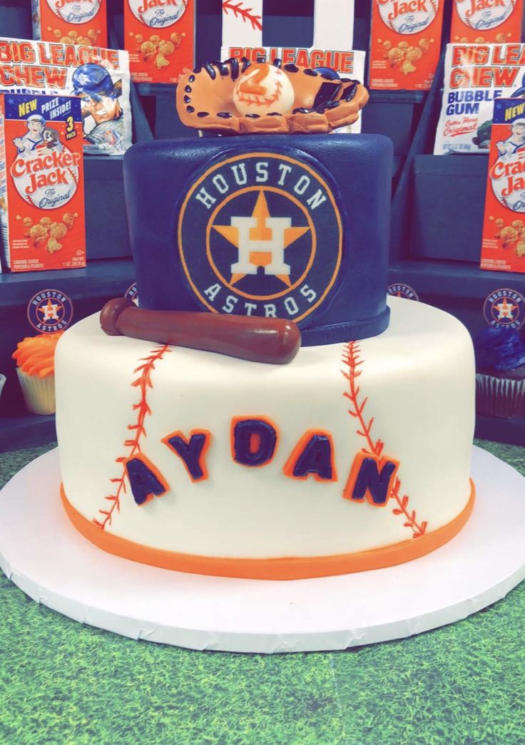 a baseball themed cake with the houston astros logo on it's bottom layer and an orange ribbon