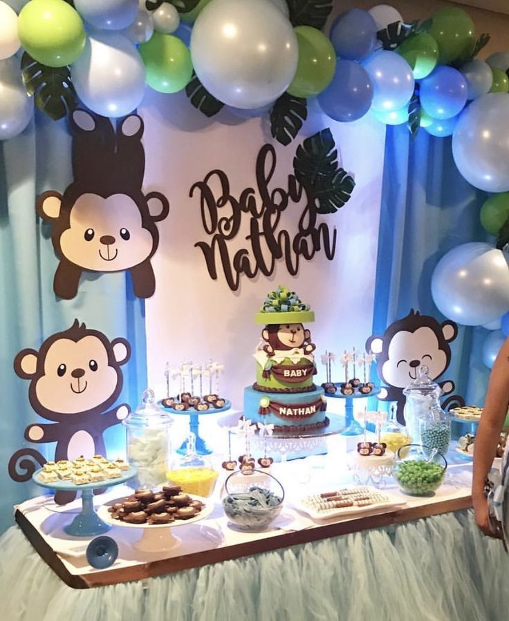 a table topped with lots of desserts and balloons in front of a wall that says baby nathan