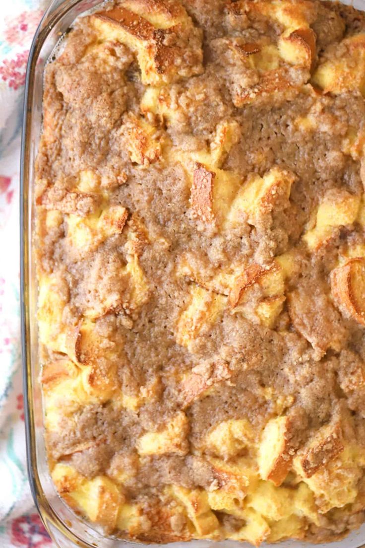 a casserole dish filled with bread and other food items on a floral cloth