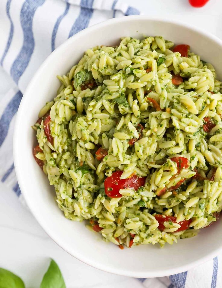 a white bowl filled with pesto pasta salad