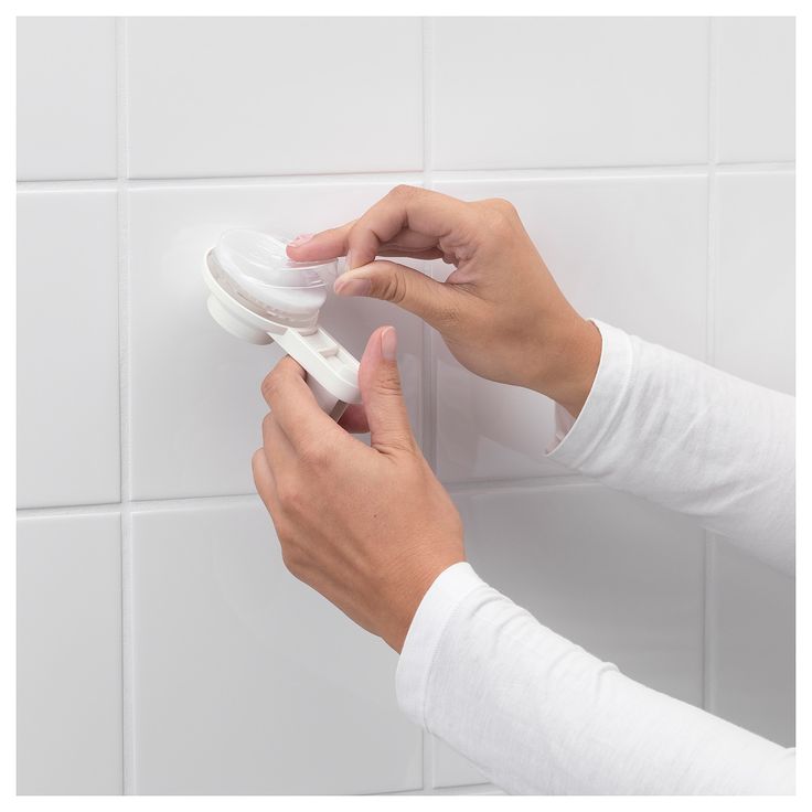 a person is using an electronic device to clean the bathroom wall tiles with their hands