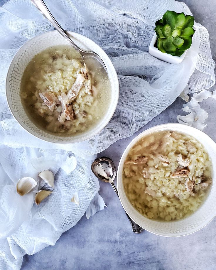 two bowls filled with soup next to a spoon