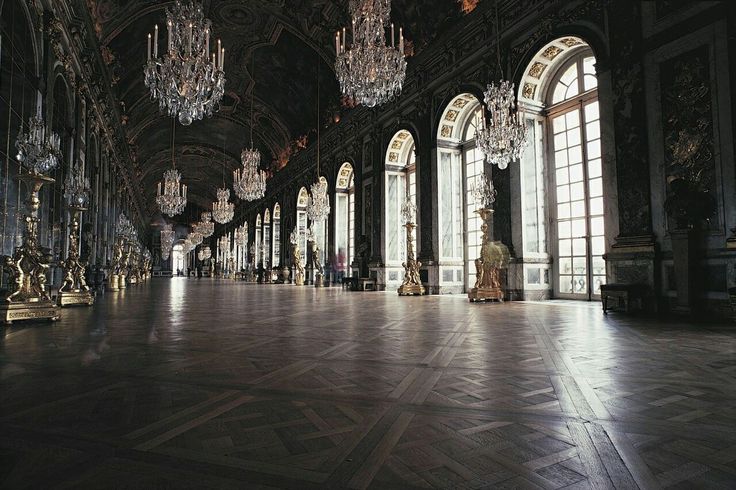 an ornate room with chandeliers and large windows