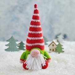 a knitted gnome is standing in the snow