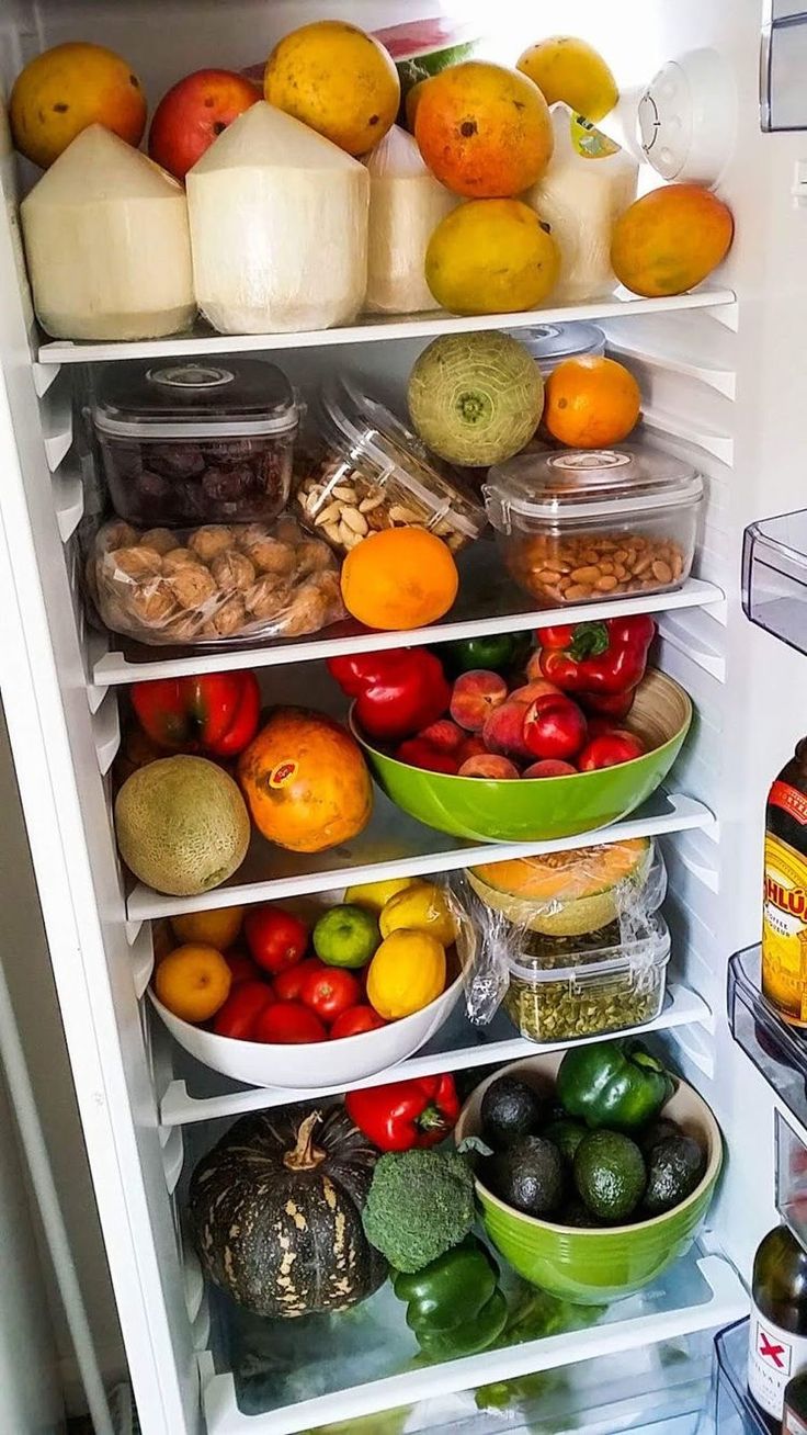 an open refrigerator filled with lots of different types of fruits and veggies in containers