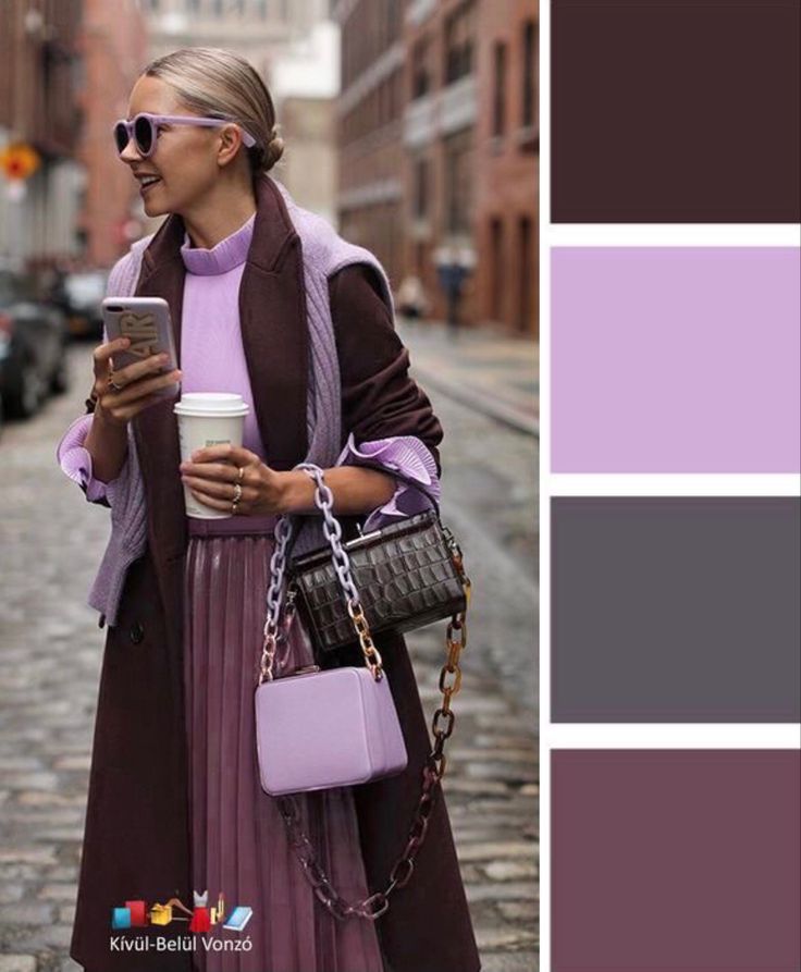 a woman is walking down the street while holding a coffee cup and looking at her cell phone