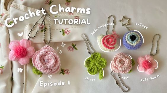 crochet charms and necklaces are displayed on a white sheet with pink flowers