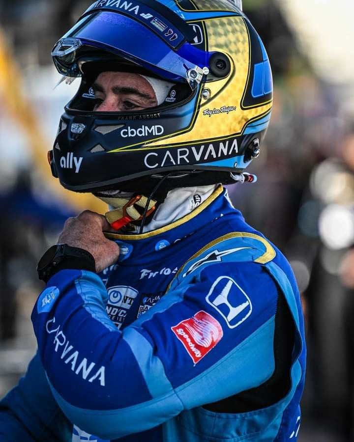 a man wearing a blue and yellow racing suit