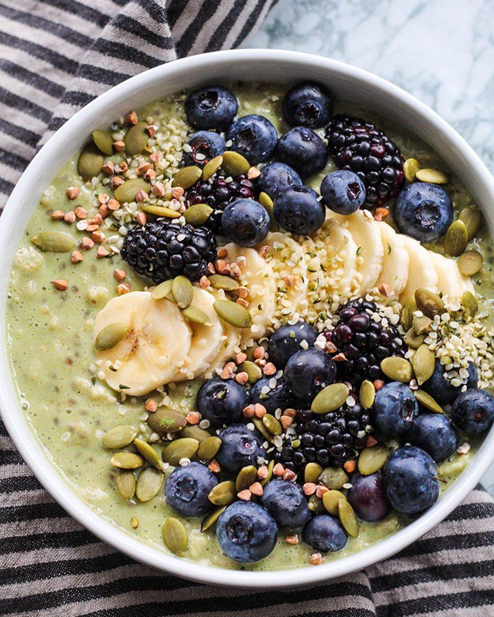 a bowl filled with bananas, blueberries and pistachios on top of a striped towel