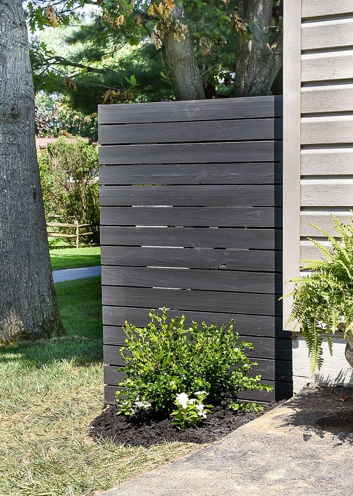 a wooden fence next to some plants and trees