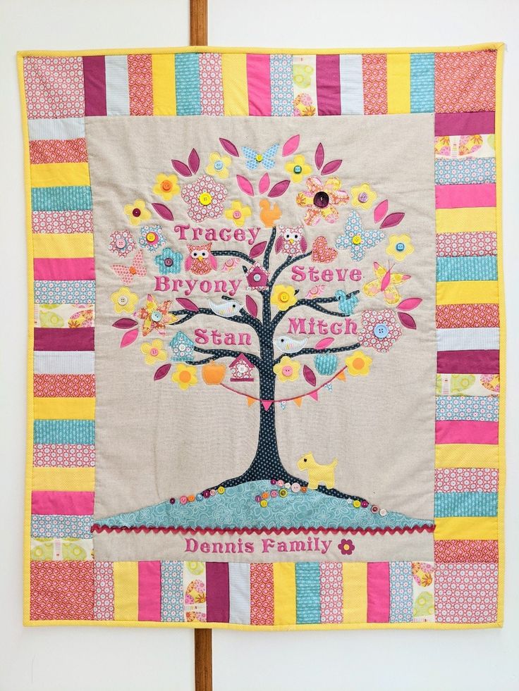 a quilt hanging on the wall with a tree