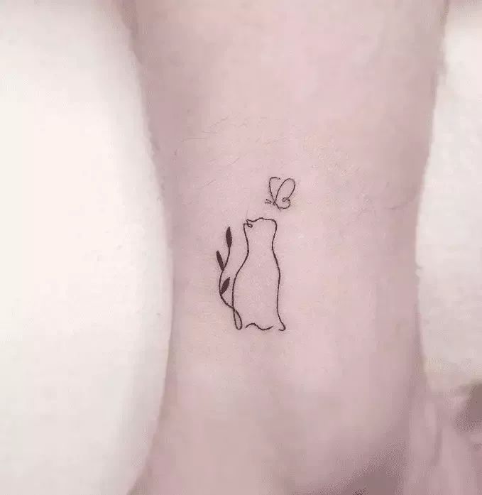 a small cat tattoo on the ankle