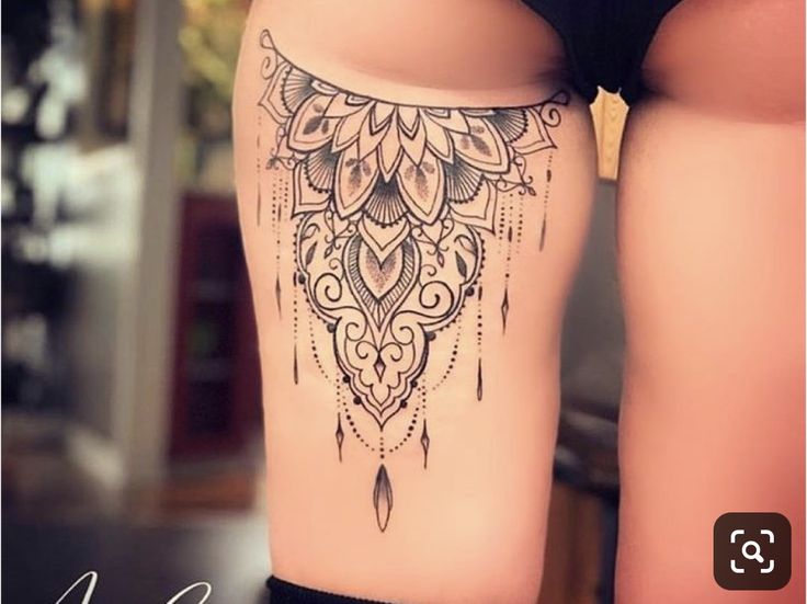 a woman's thigh with an intricate tattoo on it