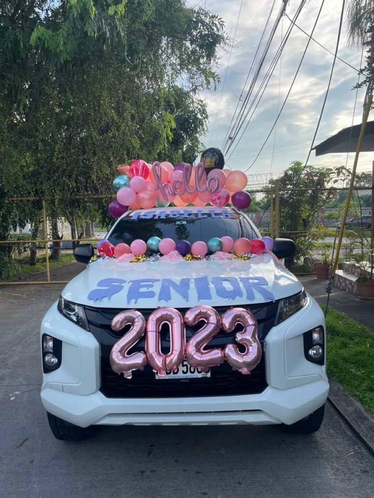 the car is decorated with balloons and streamers for someone's new year celebration