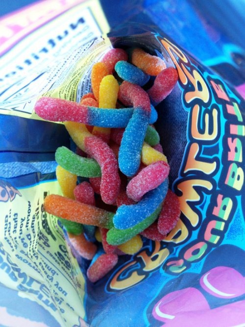 a bag filled with gummy bears sitting on top of a table next to a candy bar