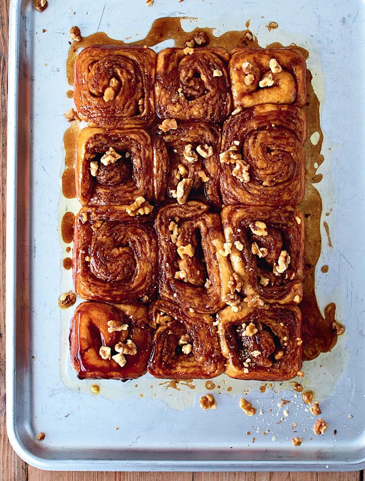 a pan filled with cinnamon rolls covered in nuts