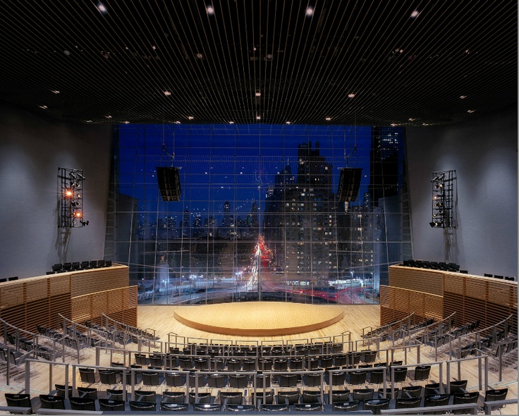 an empty concert hall with rows of seats in front of a large screen on the wall