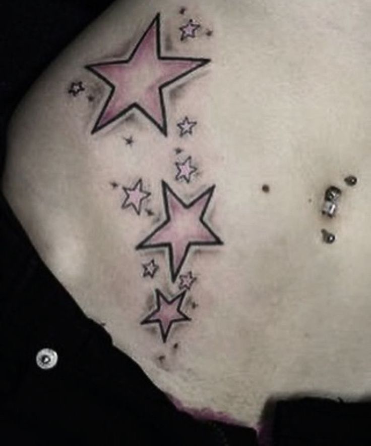 the back of a woman's stomach with stars on her left side and pink ink